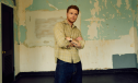 Alex Warren poses in a press shot wearing a beige checked shirt