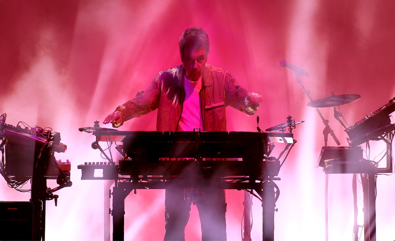 Jean-Michel Jarre performs live against a pink background