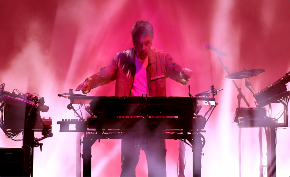 Jean-Michel Jarre performs live against a pink background