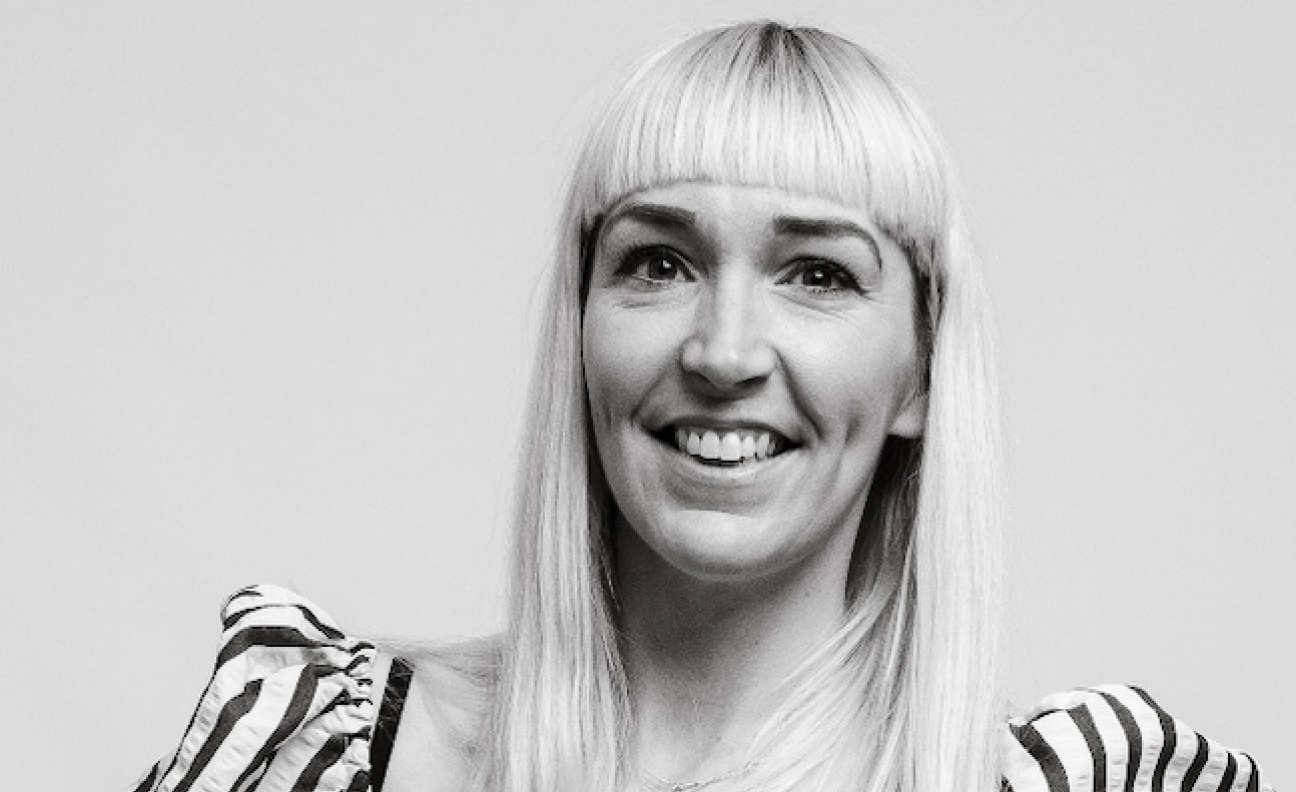 Chloe Uppington poses in a black-and-white headshot wearing a stripy top
