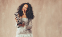 Kanya King wears a frilly dress while holding a MOBO award